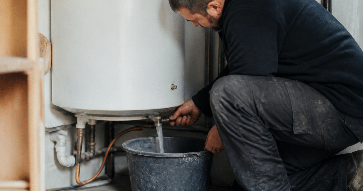 Technicien vidant un reservoir d'eau chaude blanc