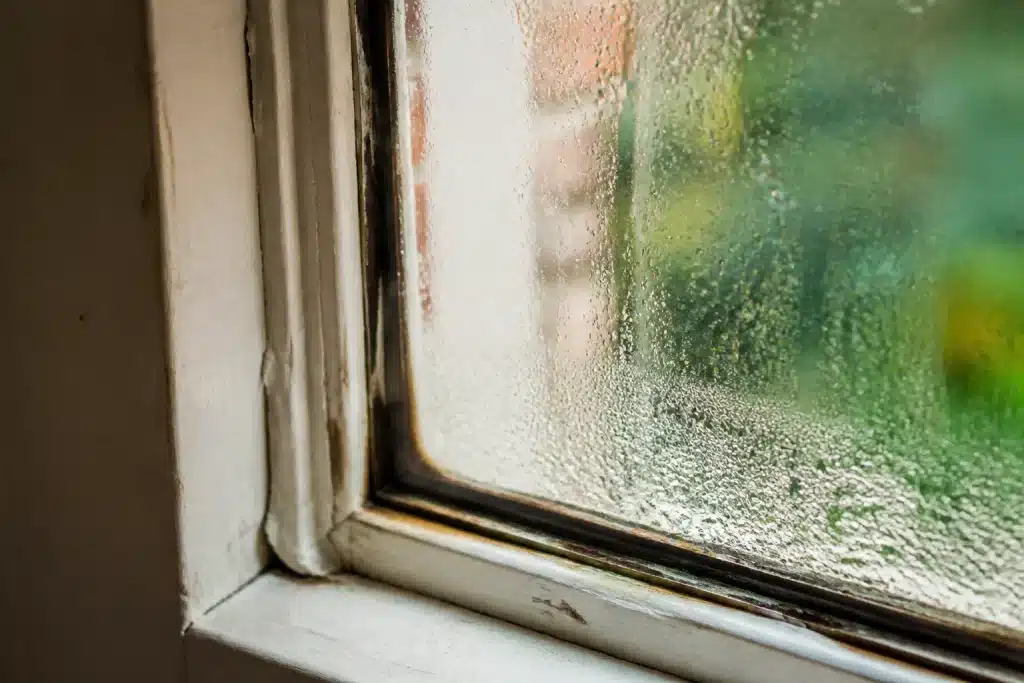 Condensation sur vitre ancienne avec joint fenetre use visible