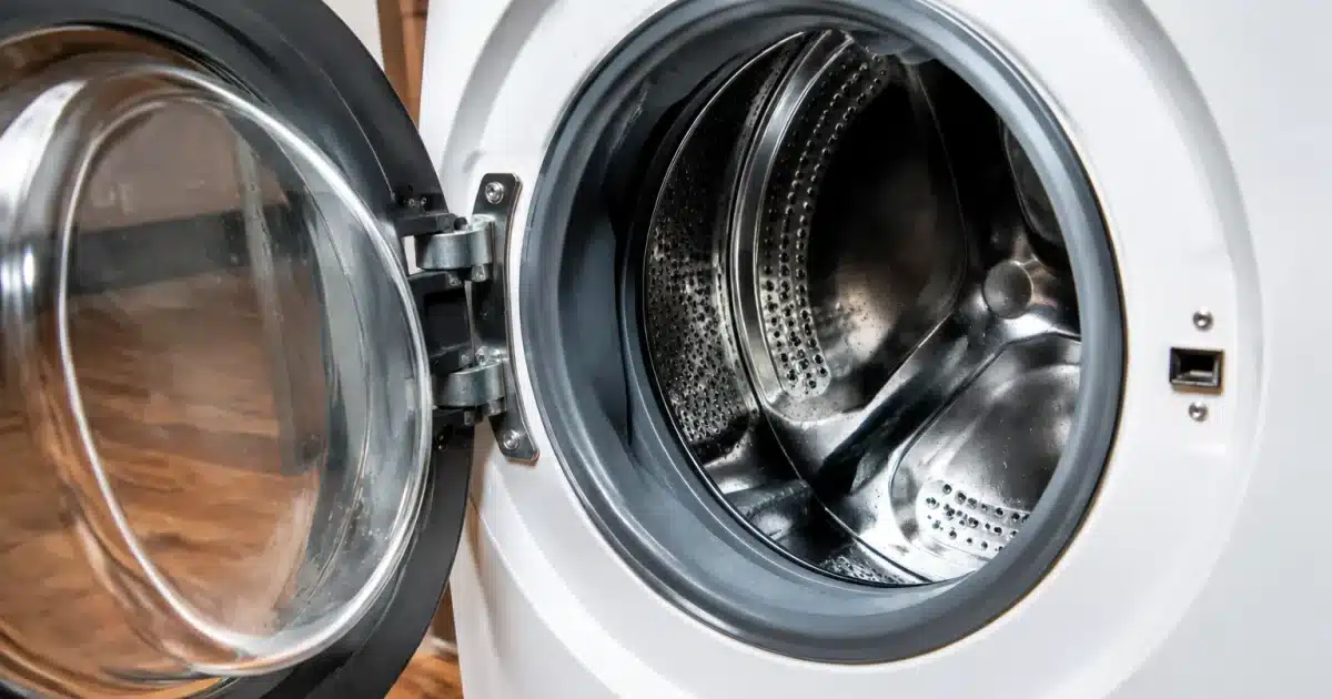 Porte de machine a laver grande ouverte revelant tambour humide a l interieur