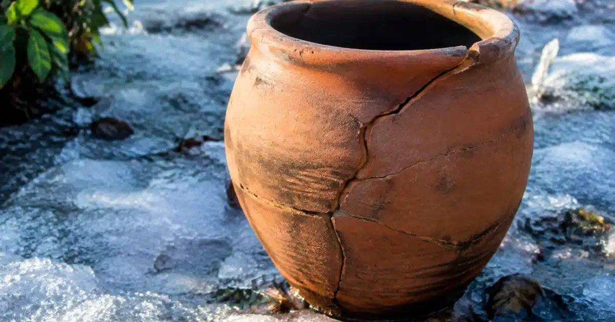Poterie en terre cuite fissurée par le froid hivernal sur sol gelé