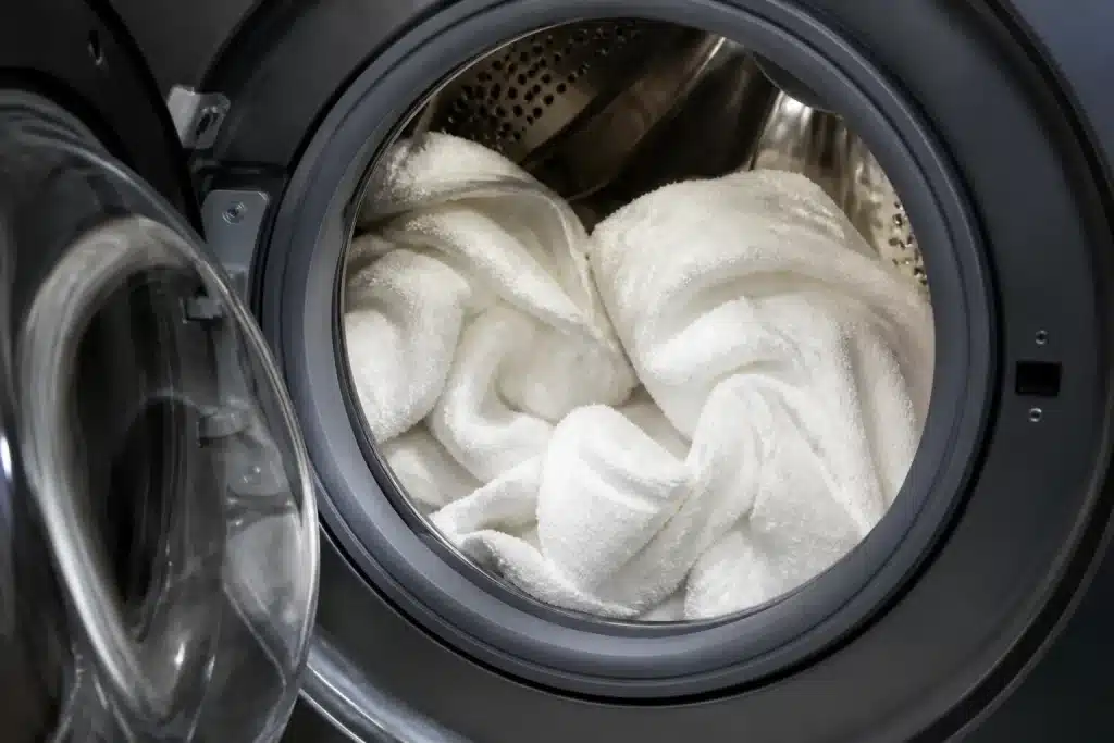 Serviettes blanches molles dans machine à laver moderne