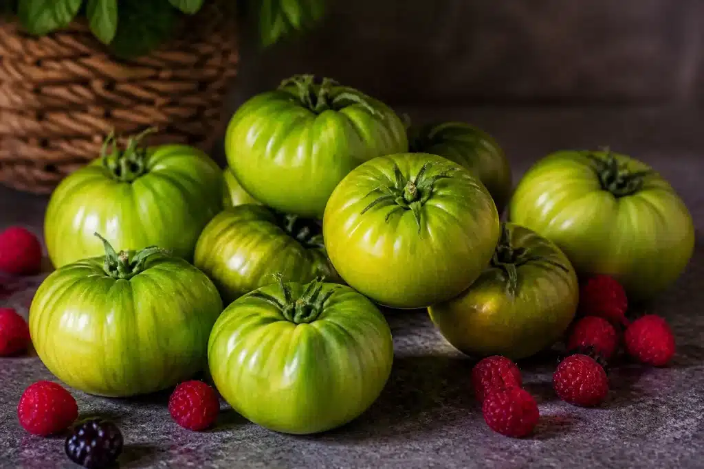 Tomates vertes disposees sur comptoir avec quelques fruits rouges