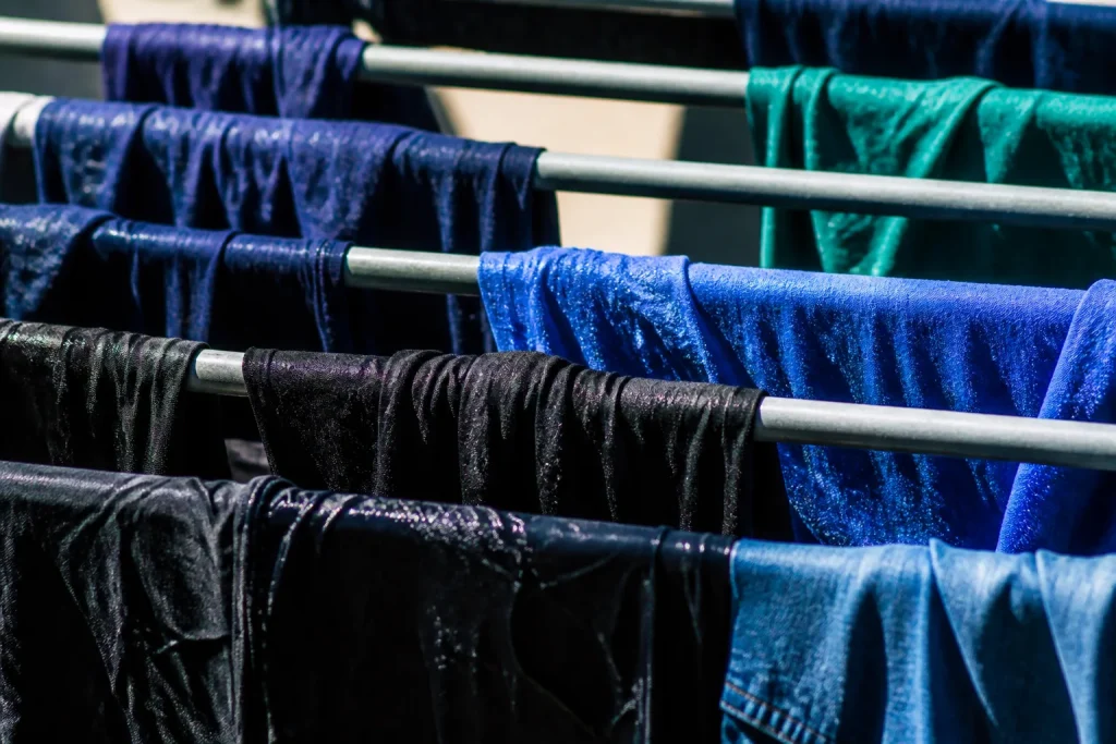 Vetements humides suspendus sur barres metalliques paralleles