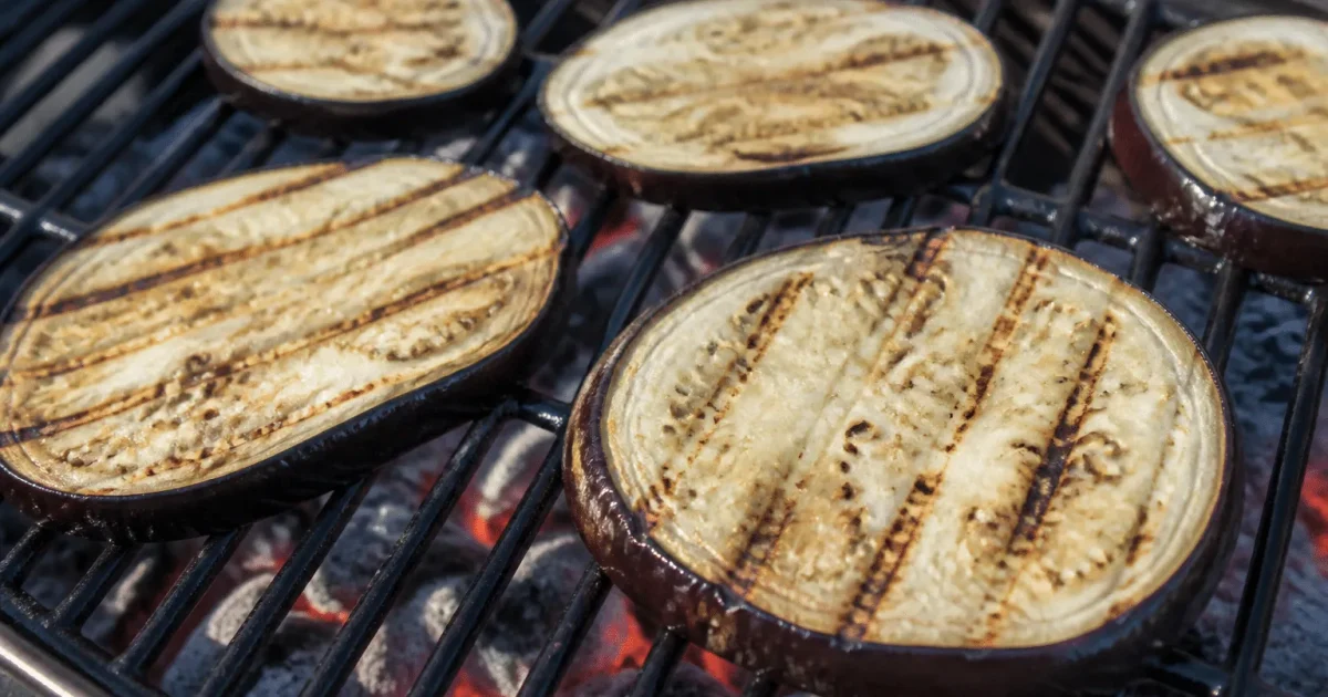 Aubergine violette tranchee posee sur grille de barbecue chaude