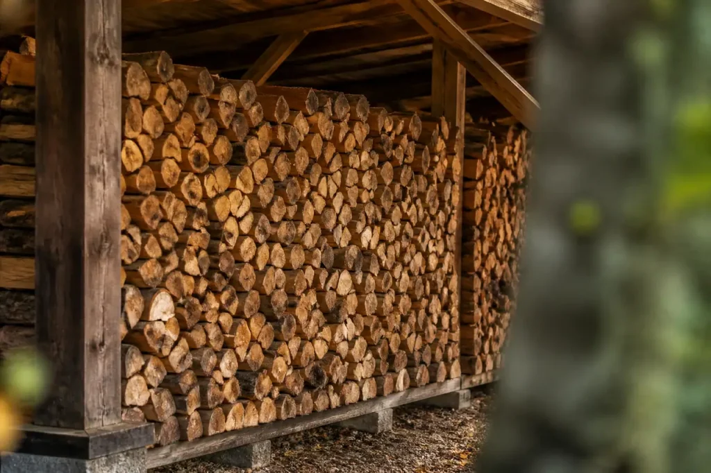 Buches de bois fendu empilees sous un abri ouvert