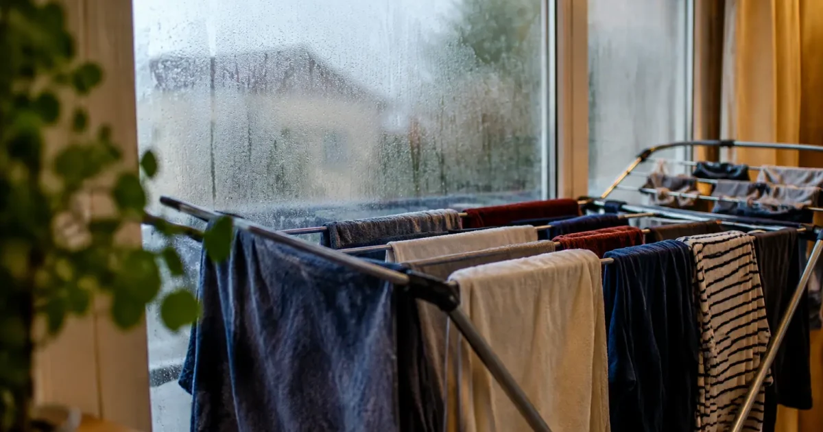 Etendoir charge de linge devant une fenetre embuee