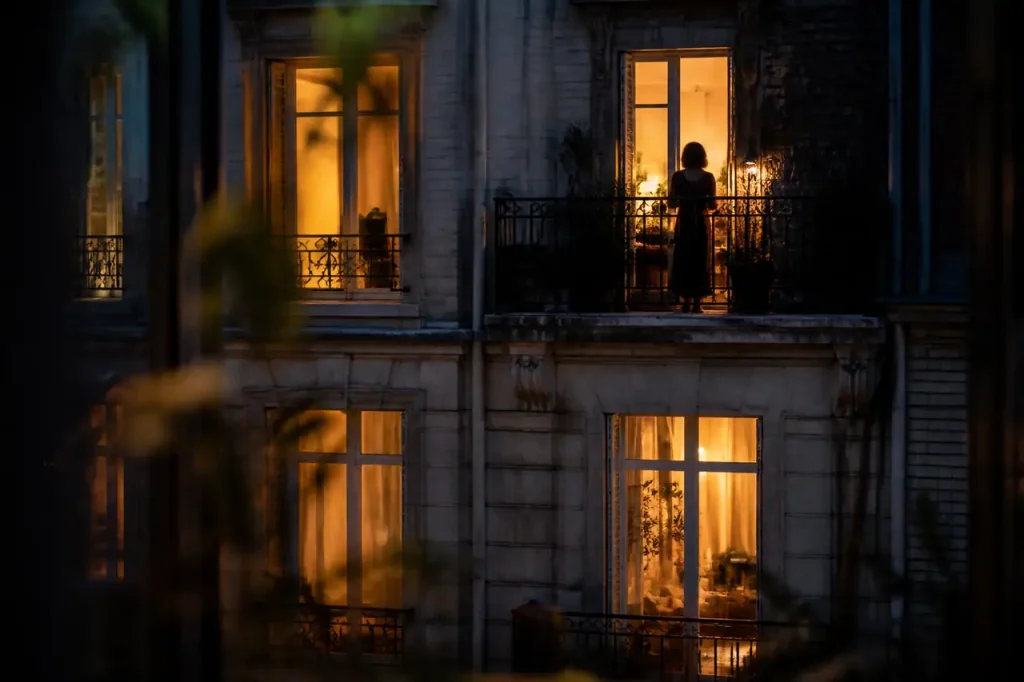 Immeuble urbain de nuit avec fenetres eclairees et balcon