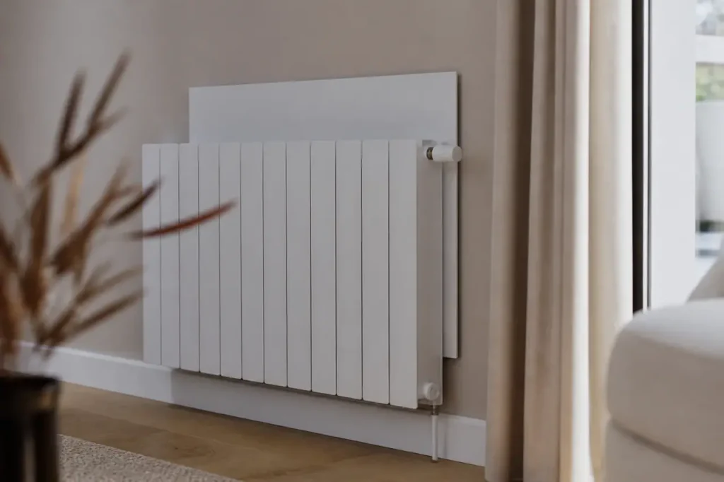 Radiateur blanc avec panneau reflecteur fixe sur le mur